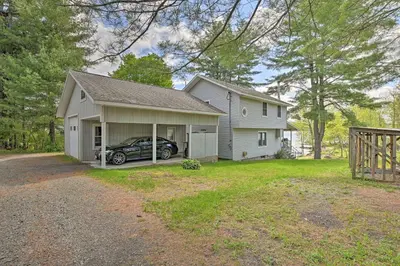 a house with a car parked in the driveway at Lakefront Gloversville Home with Beach and Dock! in Broadalbin