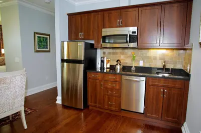 a kitchen with wooden cabinets and a stainless steel refrigerator at Guest House at Norwalk Inn in Norwalk