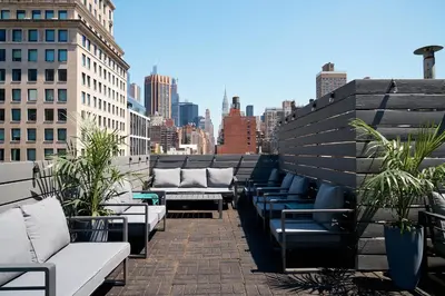 a row of benches on a balcony with a city skyline at Lex Hotel NYC in New York