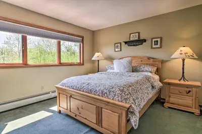 a bedroom with a large bed and two windows at Timber Creek Townhome with 2 Decks and Mtn Views! in West Dover
