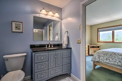 a bathroom with a sink and a toilet and a bed at Timber Creek Townhome with 2 Decks and Mtn Views! in West Dover