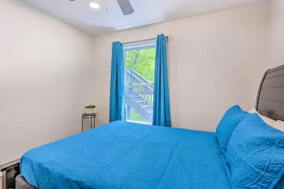a bedroom with a blue bed and a window at 2 Game Rooms! Family Poconos Home 9 Mi to Slopes in Pocono Summit