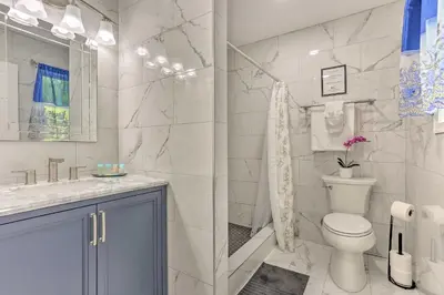 a white bathroom with a toilet and a sink at 2 Game Rooms! Family Poconos Home 9 Mi to Slopes in Pocono Summit