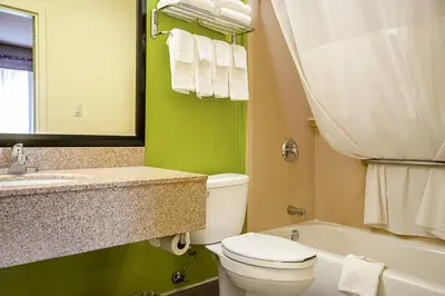 a bathroom with a toilet and a sink and a tub at Quality Inn & Suites Glenmont - Albany South in Glenmont