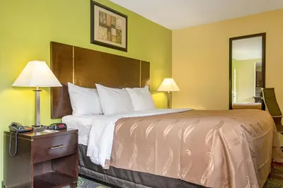 a hotel room with a large bed and a mirror at Quality Inn & Suites Glenmont - Albany South in Glenmont