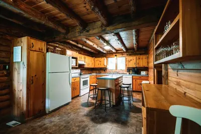 a kitchen with wooden cabinets and a white refrigerator at Afton Cabin in Afton