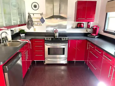 a kitchen with red cabinets and a stainless steel oven at Gorgeous Ski On/Off 2 BR Sleeps 8 Jiminy-Must See Luxury in Hancock
