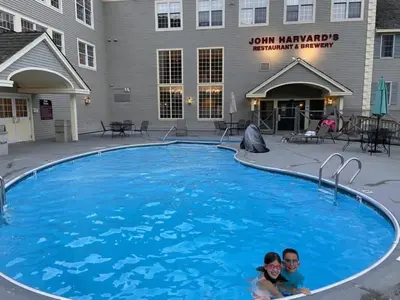 two people are laying in a large blue swimming pool at Gorgeous Ski On/Off 2 BR Sleeps 8 Jiminy-Must See Luxury in Hancock