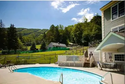 a swimming pool in a yard next to a house at Gorgeous Ski On/Off 2 BR Sleeps 8 Jiminy-Must See Luxury in Hancock