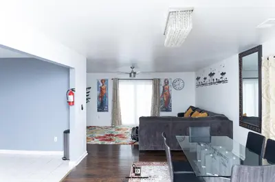 a living room with a couch and a glass table at Beautifully Designed & Spacious Apartment in Newark 10mins from EWR Airport, Close to NYC and Beth Israel Hospital in Newark