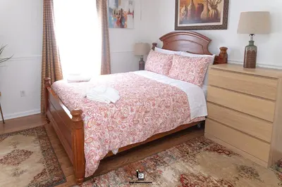 a bedroom with a bed with a wooden headboard at Beautifully Designed & Spacious Apartment in Newark 10mins from EWR Airport, Close to NYC and Beth Israel Hospital in Newark