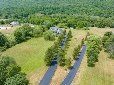 an aerial view of a house and a road in a field at Malkita Aria Mountainview Retreat in Woodbury