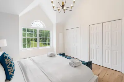 a white bedroom with a large bed and a window at Malkita Aria Mountainview Retreat in Woodbury