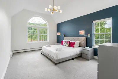 a bedroom with a large bed and two windows at Malkita Aria Mountainview Retreat in Woodbury