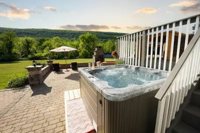a hot tub on the balcony of a house at Malkita Aria Mountainview Retreat in Woodbury