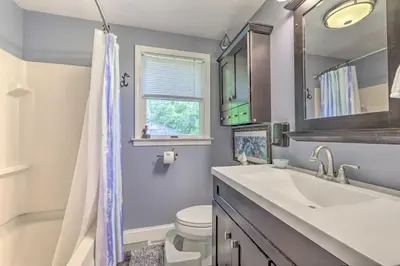a bathroom with a sink and a toilet and a window at Granby Getaway in the Woods with Spacious Yard! in Granby