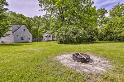 a yard with a tire in the grass at Granby Getaway in the Woods with Spacious Yard! in Granby