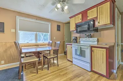 a kitchen with a table and chairs and a microwave at Granby Getaway in the Woods with Spacious Yard! in Granby