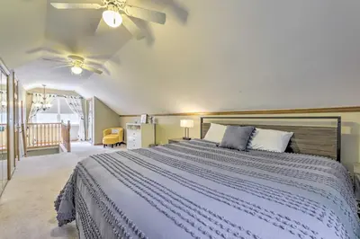 a bedroom with a large bed and a ceiling fan at Granby Getaway in the Woods with Spacious Yard! in Granby
