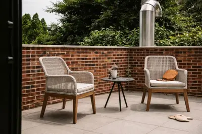 two chairs and a table next to a brick wall at Dutch Hotel Long Island City New York , Belvilla District 6 Formerly Sonder in Long Island City