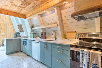 a kitchen with blue cabinets and a sink at Wilmington Chalet with Hot Tub Less Than 8 Mi to Mount Snow! in Wilmington