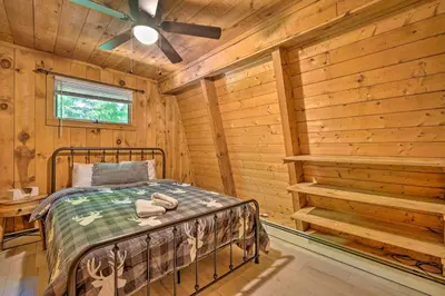 a bedroom with a bed in a log cabin at Wilmington Chalet with Hot Tub Less Than 8 Mi to Mount Snow! in Wilmington