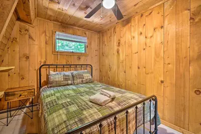 a bedroom with a bed in a wooden cabin at Wilmington Chalet with Hot Tub Less Than 8 Mi to Mount Snow! in Wilmington