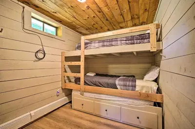 a bedroom in a log cabin with bunk beds at Wilmington Chalet with Hot Tub Less Than 8 Mi to Mount Snow! in Wilmington