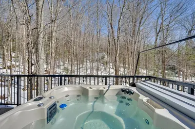 a hot tub on a balcony with a view of trees at Wilmington Chalet with Hot Tub Less Than 8 Mi to Mount Snow! in Wilmington