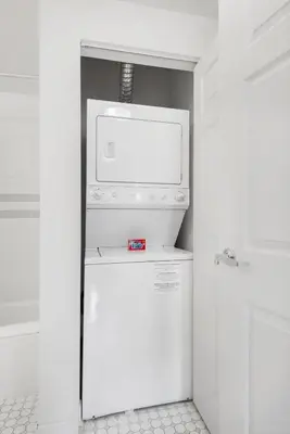 a white refrigerator with a microwave on top of it at Furnished Quarters at Grove Pointe in Jersey City
