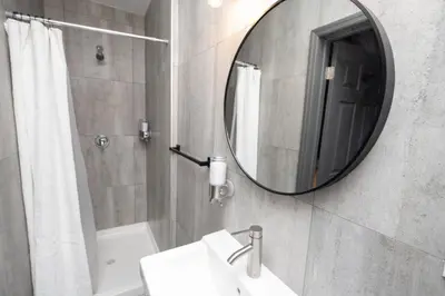 a bathroom with a sink and a mirror at The Flat NYC in New York