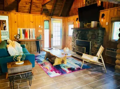 a living room with a blue couch and a fireplace at Bear Cottage in Birchwood Lakes