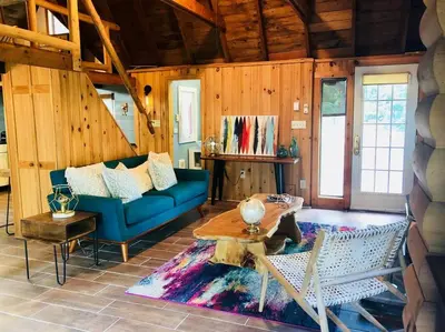 a living room with a blue couch and a table at Bear Cottage in Birchwood Lakes