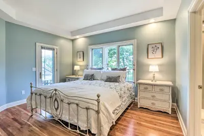 a bedroom with a bed and two windows at Elegant Middlefield Getaway with Game Room! in Middlefield