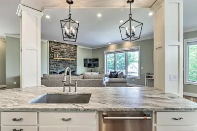 a kitchen with a sink and a living room at Elegant Middlefield Getaway with Game Room! in Middlefield