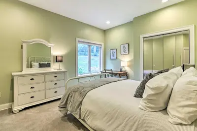 a bedroom with a bed and a dresser and a mirror at Elegant Middlefield Getaway with Game Room! in Middlefield