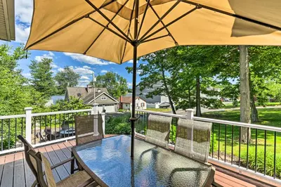 a table and chairs with an umbrella on a deck at Elegant Middlefield Getaway with Game Room! in Middlefield