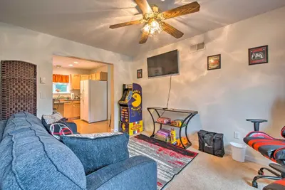 a living room with a blue couch and a ceiling fan at Jacuzzi and Resort Amenities Tobyhanna Family Home! in Tobyhanna