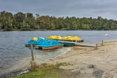a group of boats docked on the shore of a lake at Jacuzzi and Resort Amenities Tobyhanna Family Home! in Tobyhanna
