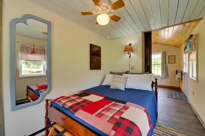 a bedroom with a bed with a mirror and a ceiling fan at Quiet Country Escape Fire Pit, Fish On-Site! in Leonardsville