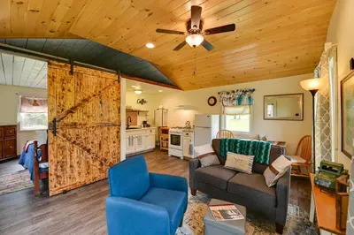 a living room with a couch and a barn door at Quiet Country Escape Fire Pit, Fish On-Site! in Leonardsville