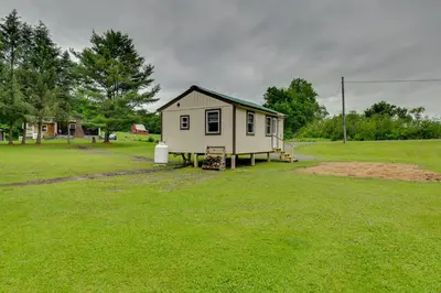 a small house in the middle of a field at Quiet Country Escape Fire Pit, Fish On-Site! in Leonardsville