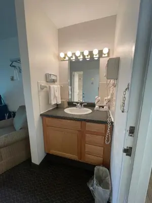 a bathroom with a sink and a mirror at Colonial Brick Inn & Suites in Susquehanna
