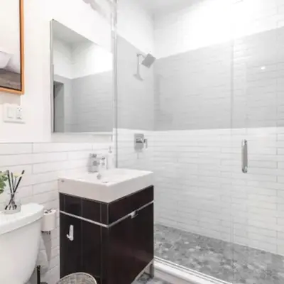 a bathroom with a sink and a glass shower at Modern Holiday Apartment with Strategic Location in New York in New York