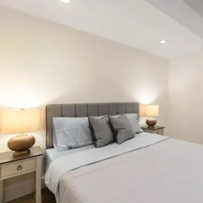 a white bedroom with a large bed with two lamps at Modern Holiday Apartment with Strategic Location in New York in New York