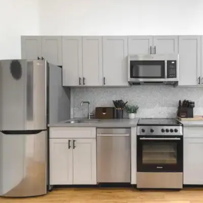 a kitchen with white cabinets and stainless steel appliances at Modern Holiday Apartment with Strategic Location in New York in New York