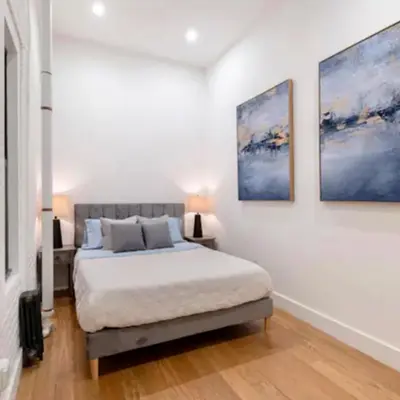 a bedroom with a bed and two paintings on the wall at Modern Holiday Apartment with Strategic Location in New York in New York
