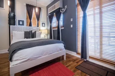 a bedroom with blue walls and a bed with a red rug at Henry Norman Hotel in Brooklyn