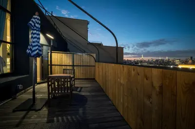 a table and chairs on the balcony of a building at Henry Norman Hotel in Brooklyn