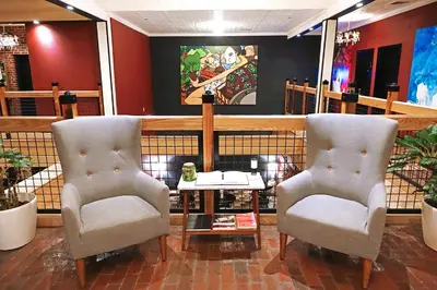 two chairs and a table in a room at Henry Norman Hotel in Brooklyn
